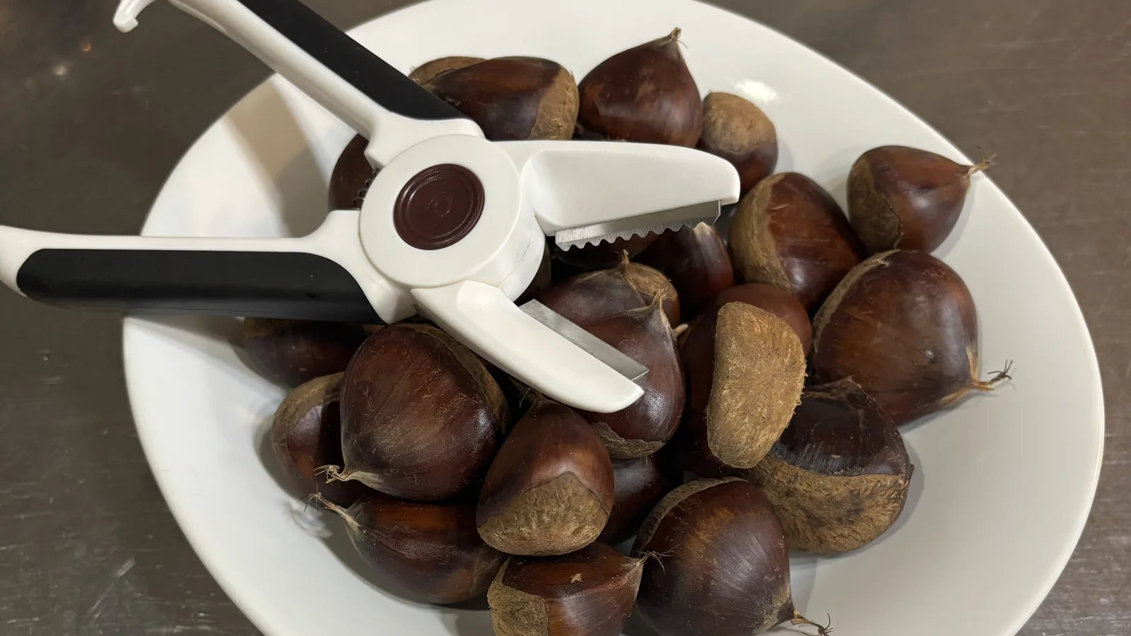茹でた栗が盛られたお皿と、はさみ型の栗むき器
